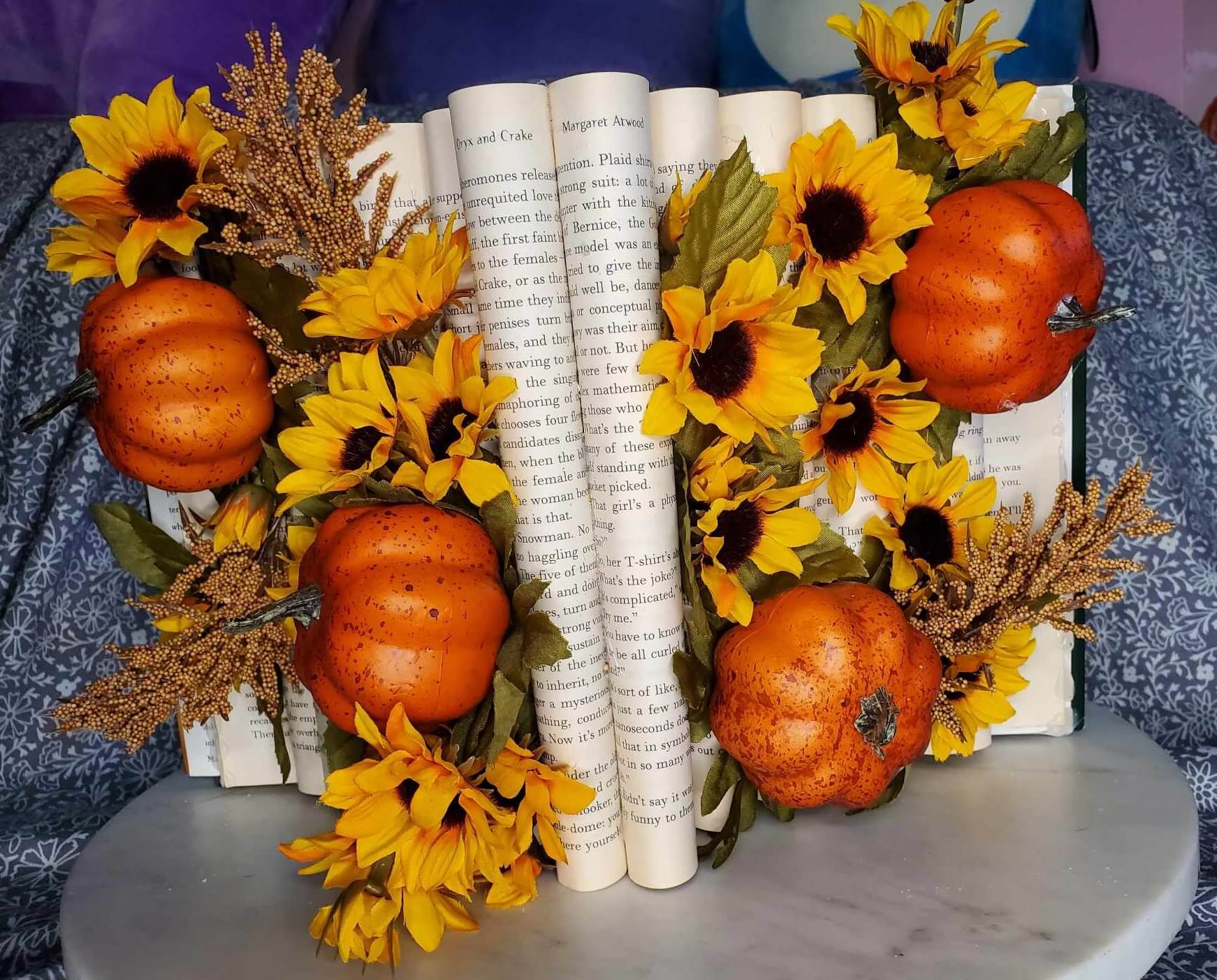 Book with folded pages. Pumpkins and sunflowers are arranged throughout the folds.